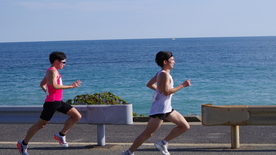 海の見えるコースを快走するランナー