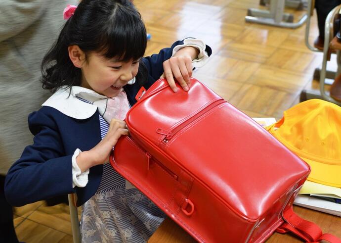 写真：ランドセルを開ける女の子