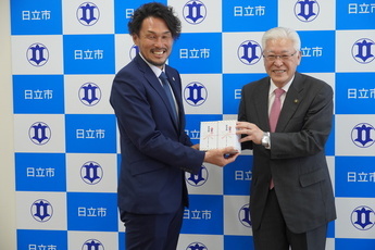 小川市長から本間さんへの記念品贈呈