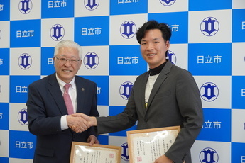 「まちのこ団」代表理事の増田大和さんと握手を交わす小川市長